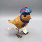 A little wooden garden bird wearing a pink and green tartan Scottish beret and matching scarf