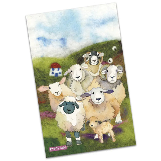 A tea towel featuring an illustration of sheep on a felted field background