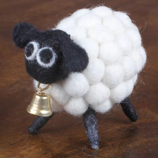 A white pompom sheep figurine with a brass bell