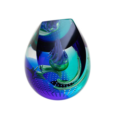 A chisel shaped glass paperweight with swirling purple and blue, a thistle head in the centre, and bubble details mirror