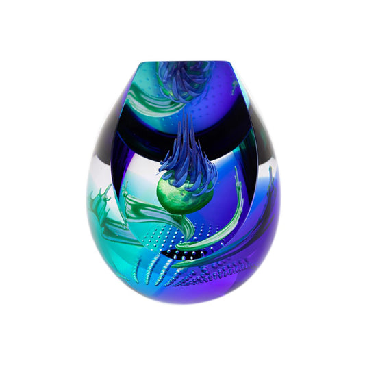 A chisel shaped glass paperweight with swirling purple and blue, a thistle head in the centre, and bubble details