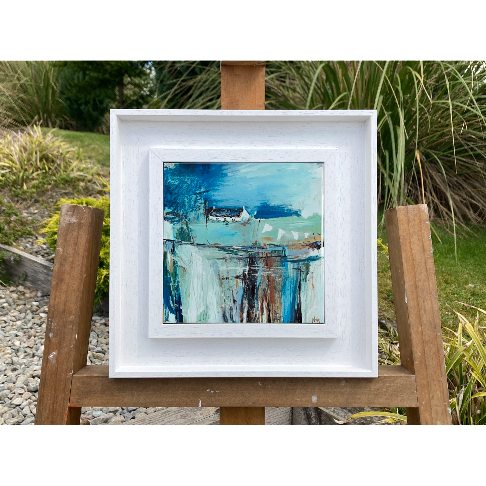 White framed art tile featuring a small white bothy in a vibrant blue setting