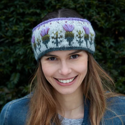 Model wearing a headband featuring a repeating row of purple thistles and hearts