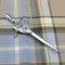A saltire shield and thistle design pewter kilt pin on tartan background