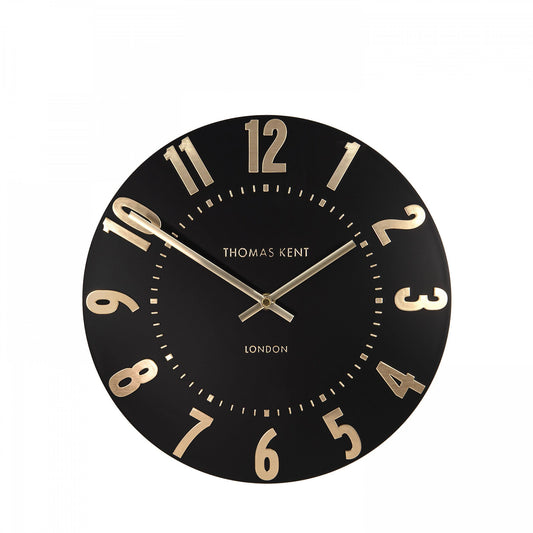 A simple and modern round wall clock in a black colour with gold hands and numbers