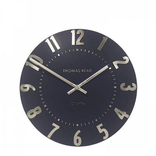 A simple and modern round wall clock in a dark slate grey colour with gold hands and numbers
