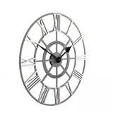 Side view of round skeleton wall clock with grey frame, black hands and silver roman numerals.