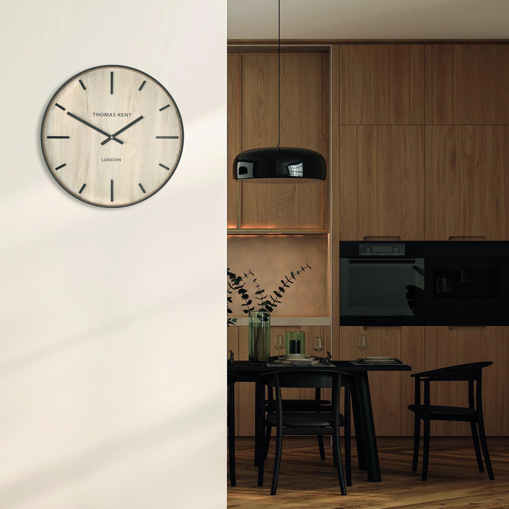 A wall clock with light wood effect face and simple number markings and hands on wall