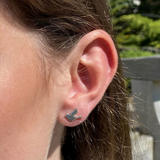 Model wearing simple silver bird shaped earrings with stud fittings