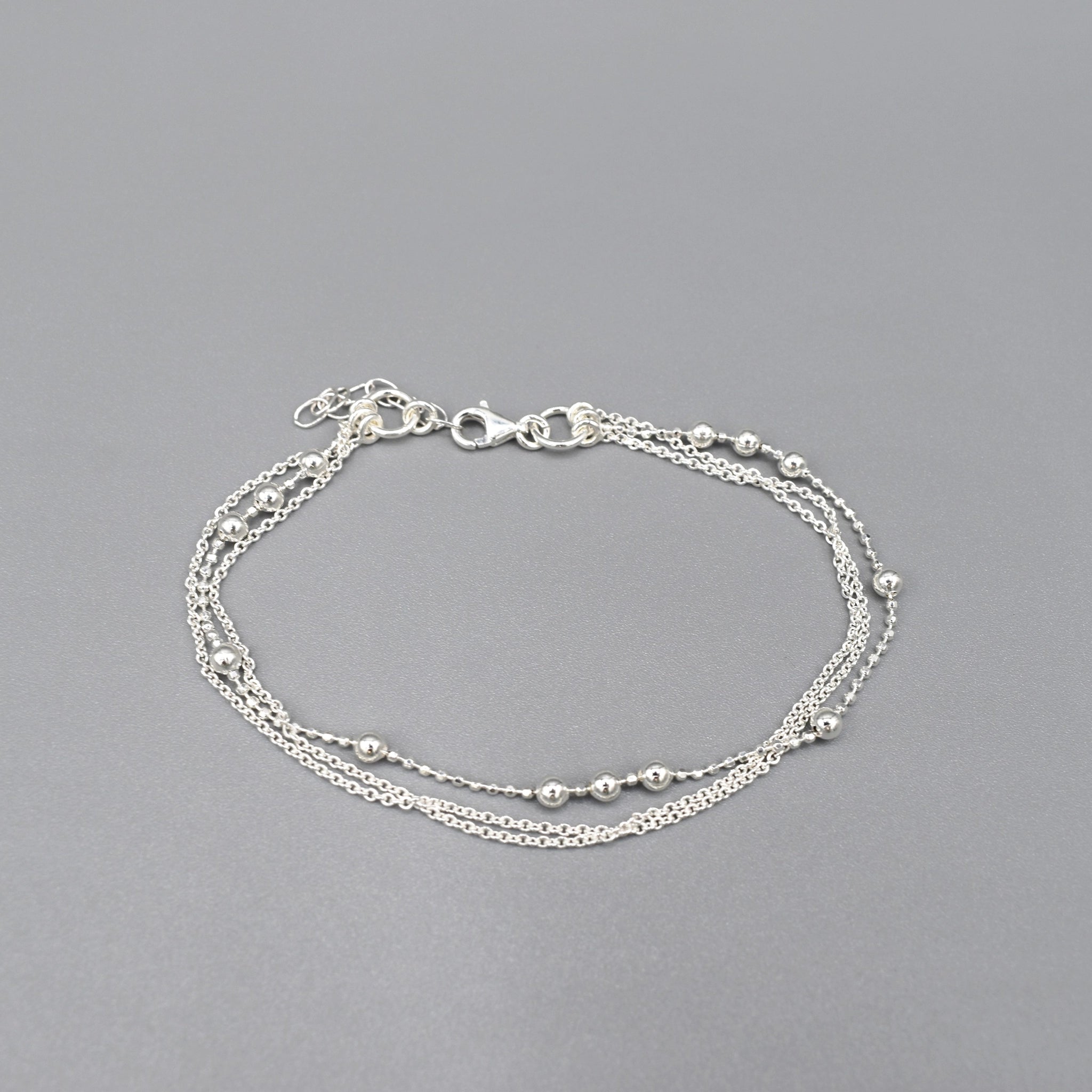 Bracelet with two delicate silver chains and one chain with spaced silver ball beads and lobster clasp