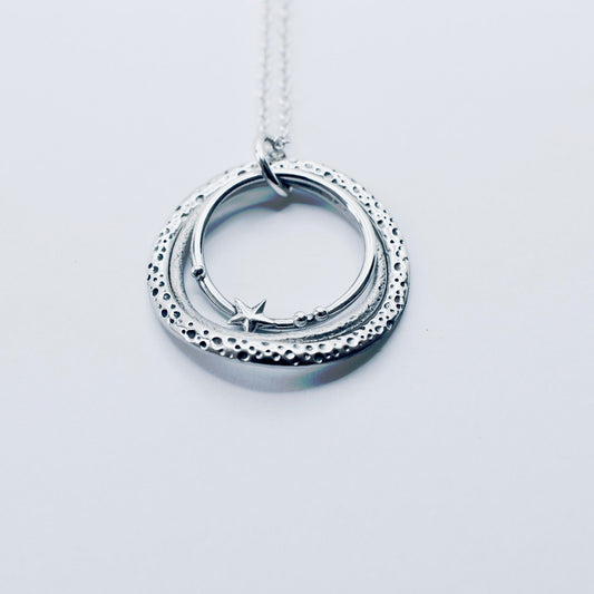 Silver necklace with three graduated circles with texture and pebble and star shapes