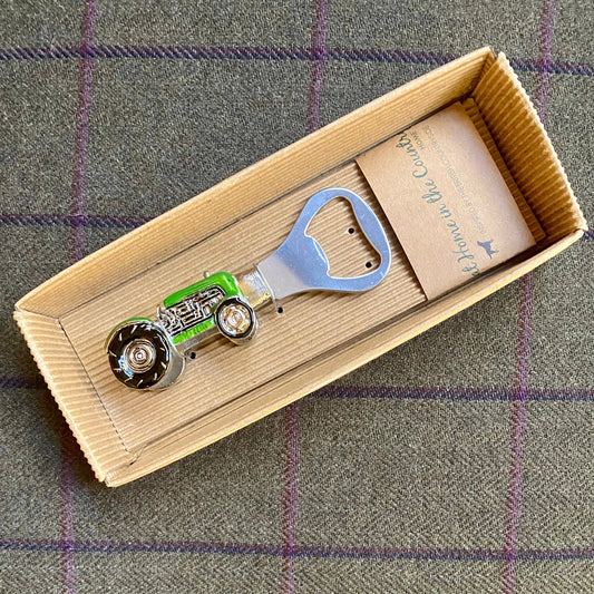 An enamelled bottle opener with a tractor shaped handle in box