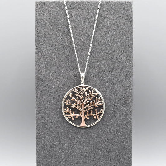 A round pendant with a rose gold tree of life