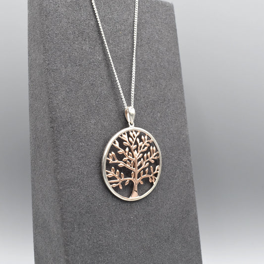 A round pendant with a rose gold tree of life 