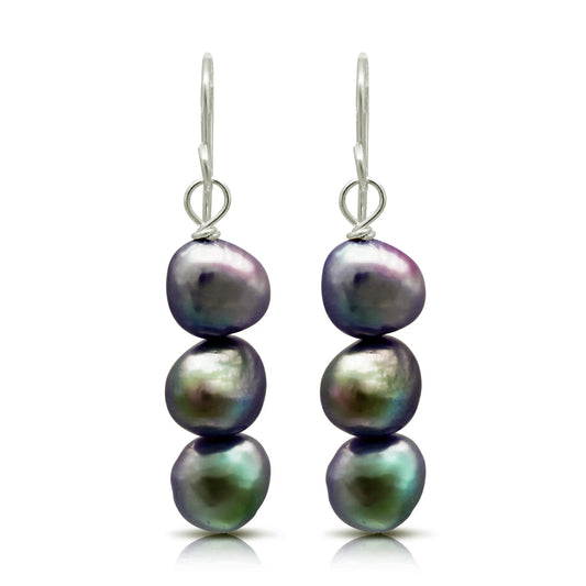 A pair of drop earrings with three stacked natural shaped black pearls and silver hook fittings