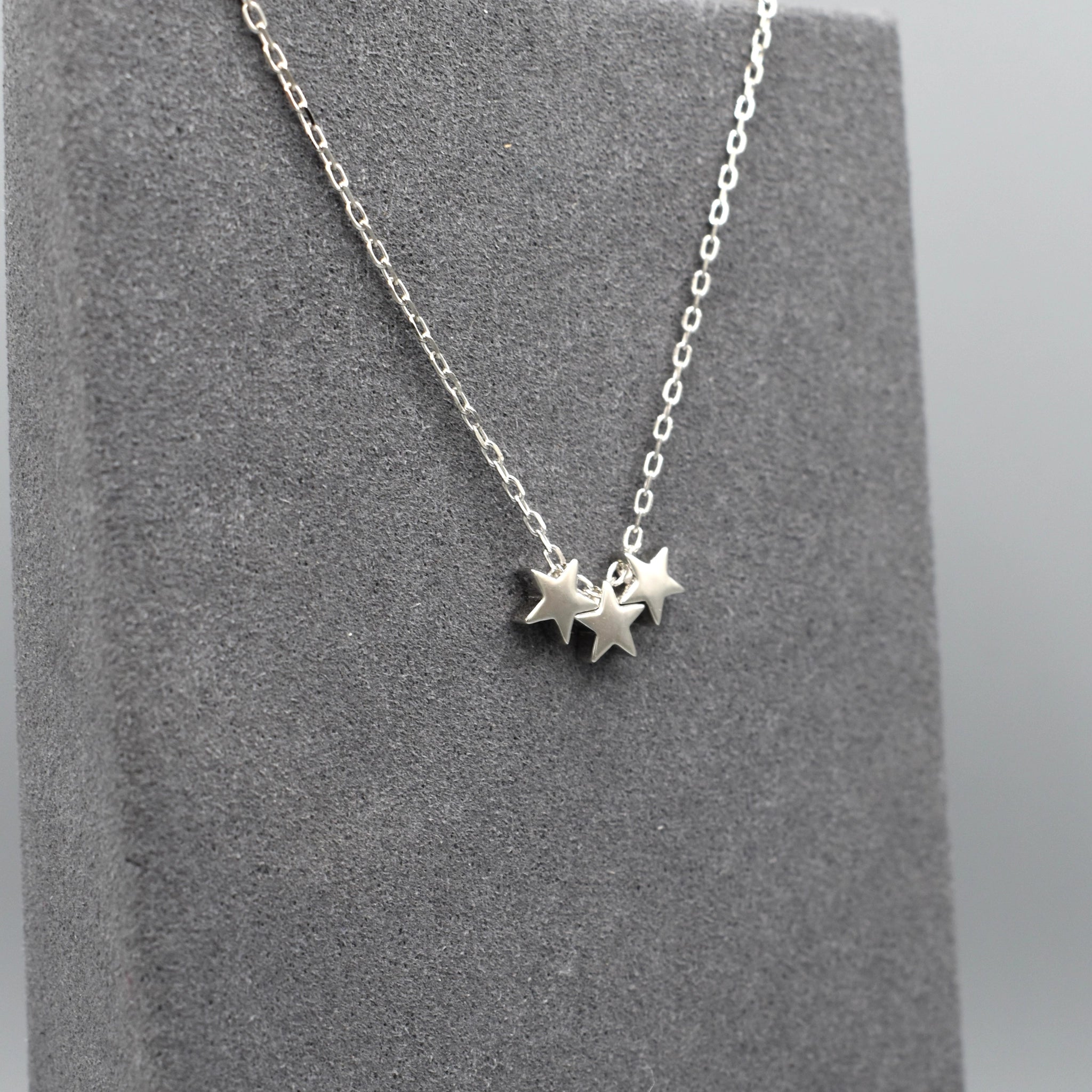 A silver necklace featuring three little stars