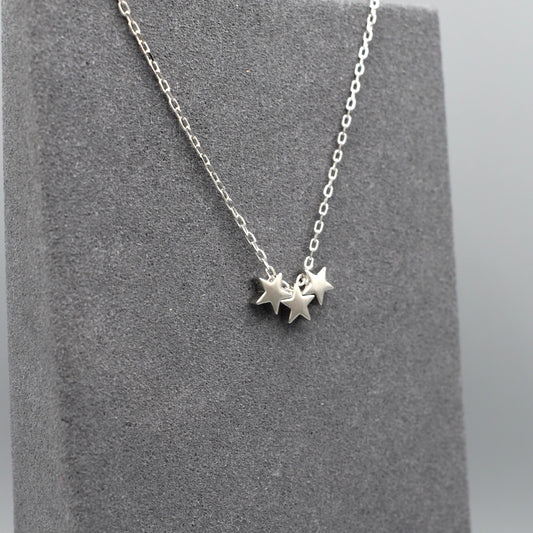 A silver necklace featuring three little stars