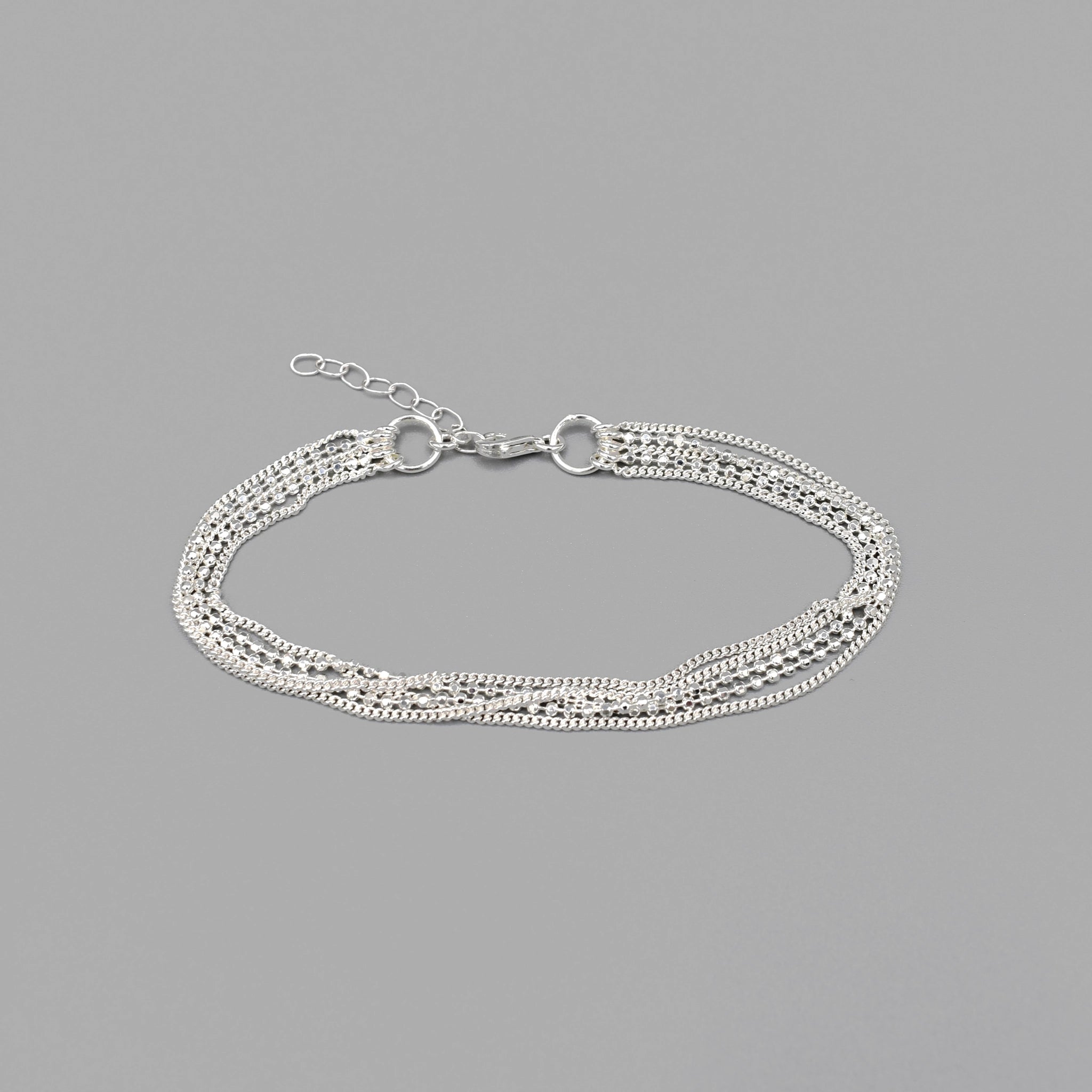 A sterling silver bracelet featuring three delicate silver chains and a double ball chain strand with lobster clasp