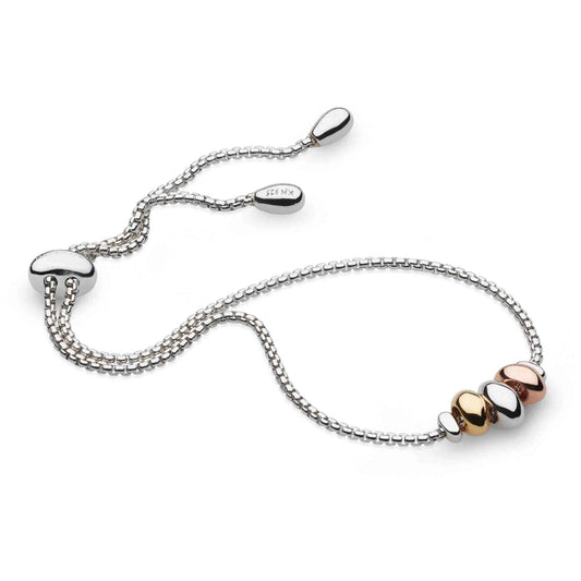 A silver bracelet with mixed metal organic pebble shapes and toggle clasp