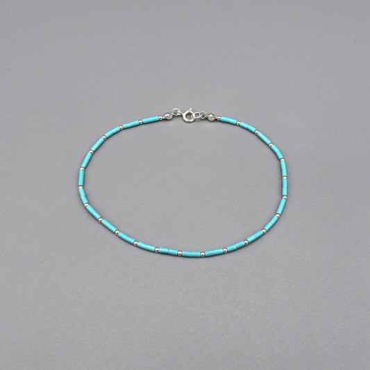 A beaded anklet with cylindrical turquoise and silver ball spacers