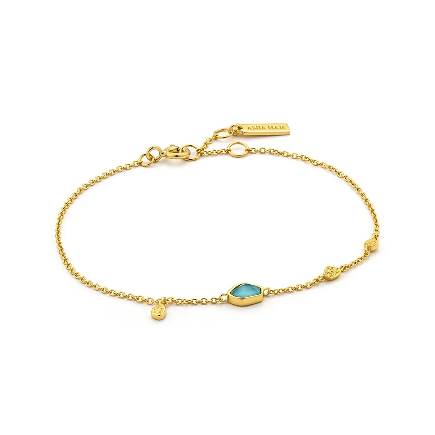 A gold bracelet with irregular turquoise stone and three gold discs