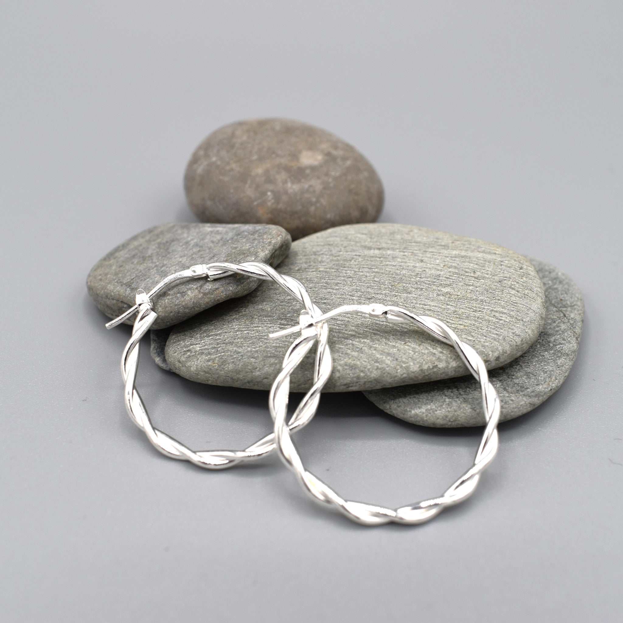 A pair of twist design silver hoop earrings