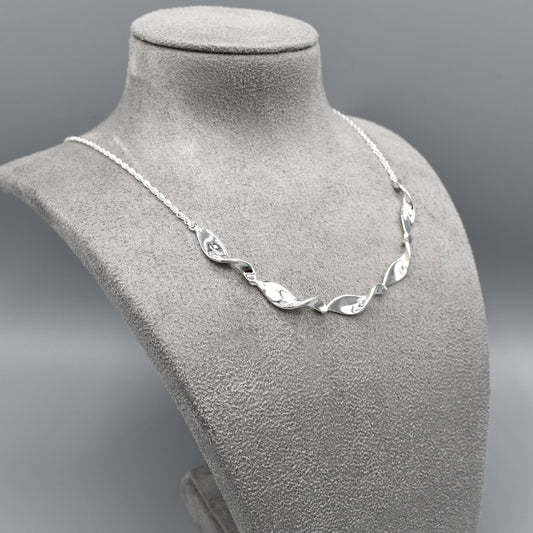 This sterling silver necklace features simple silver twist shaped links