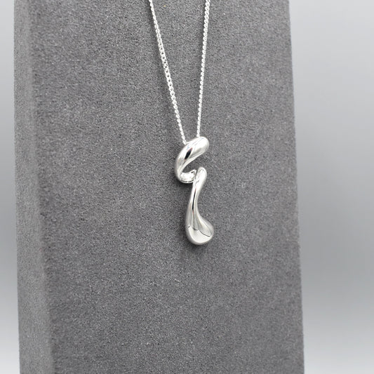 A sterling silver pendant that features a modern design of a long twisted droplet shape