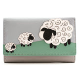 A grey leather purse featuring an applique of three sheep in a field