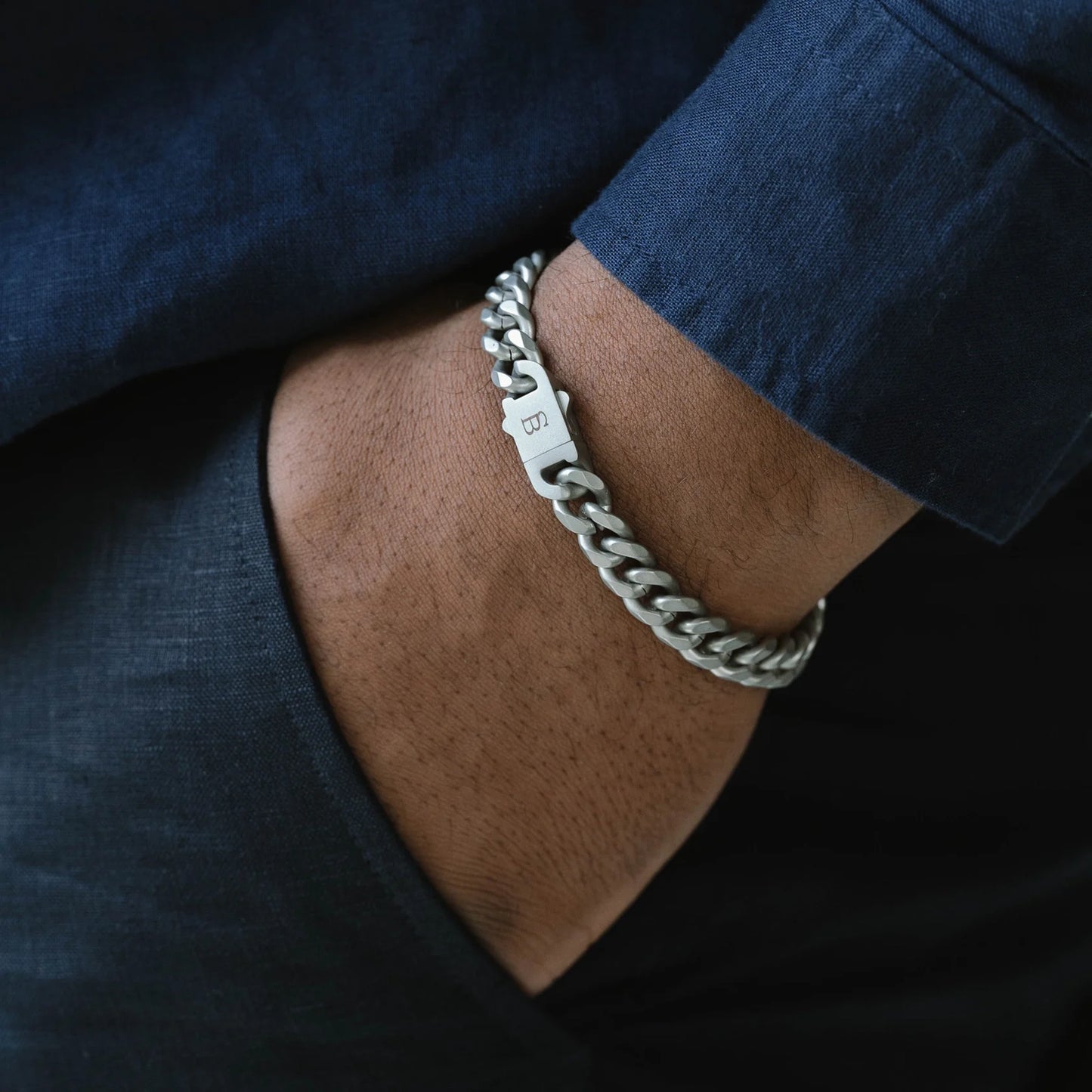 Model wearing a silver chunky chain bracelet made from stainless steel, with a snap clasp fastening