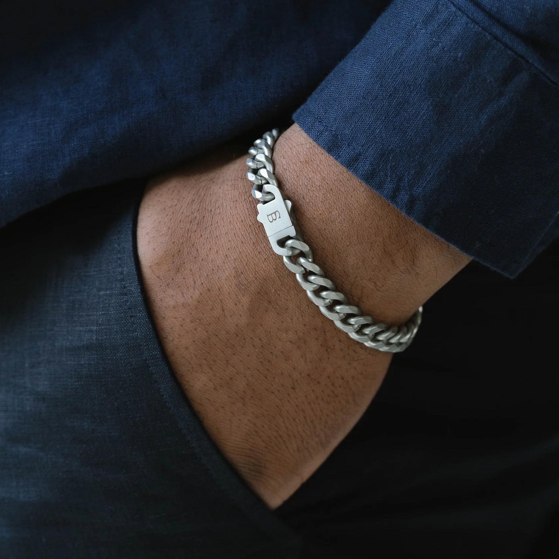 Model wearing a silver chunky chain bracelet made from stainless steel, with a snap clasp fastening