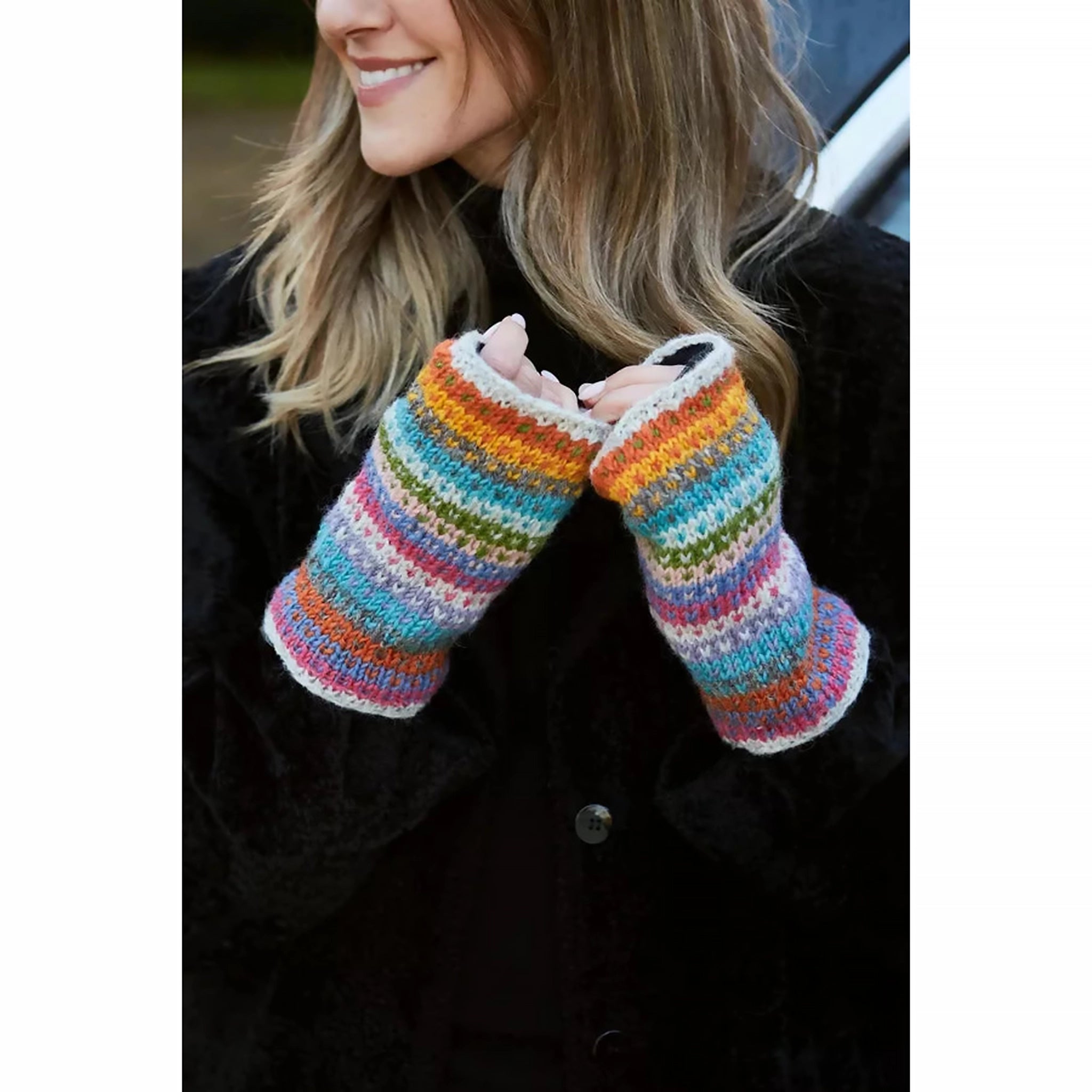 A pair of knitted hand warmers with rainbow pastel stripe pattern and small chevron hearts