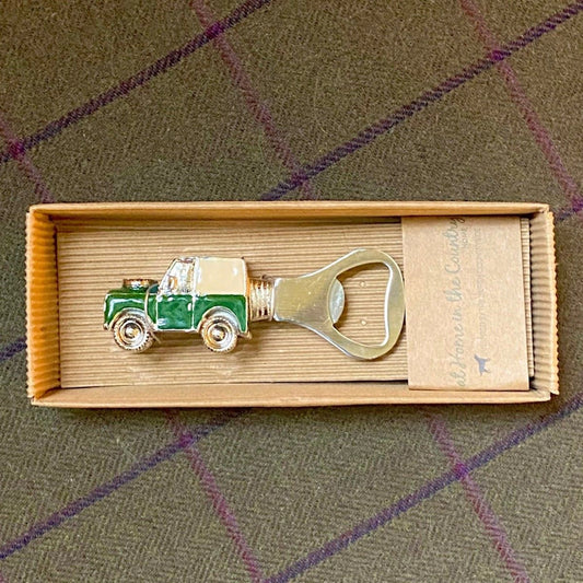 An enamelled bottle opener with a vintage Land Rover car on top box