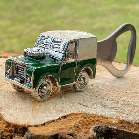 An enamelled bottle opener with a vintage Land Rover car on top