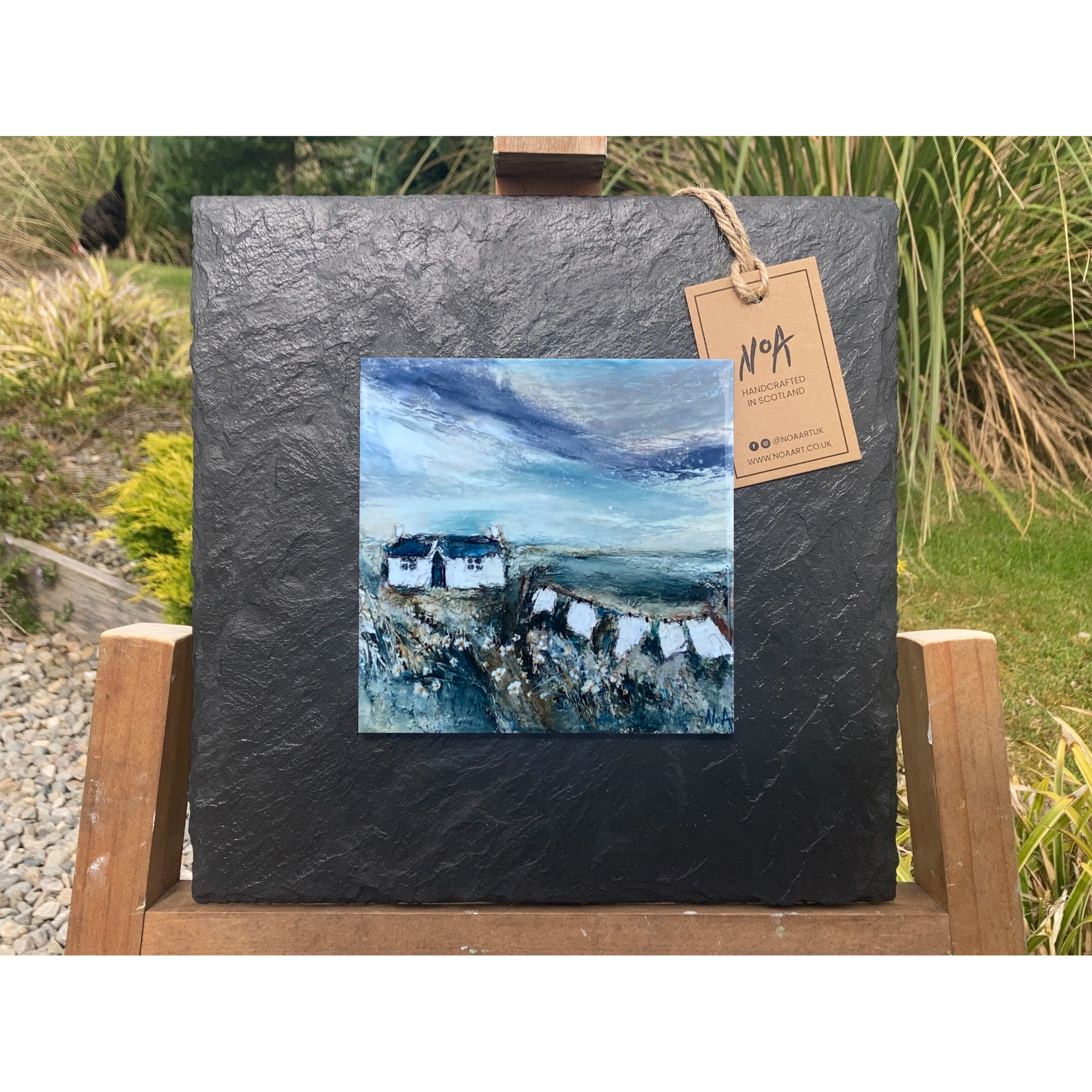 Slate mounted ceramic tile art featuring a painting of a white cottage and washing line