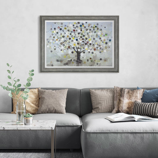 Framed print of an impressionist tree with multi coloured vintage watch faces over the branches hanging in light room.
