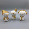 Three snowman ornaments with gold glitter, one with a Santa hat, one with a top hat and one with earmuffs 