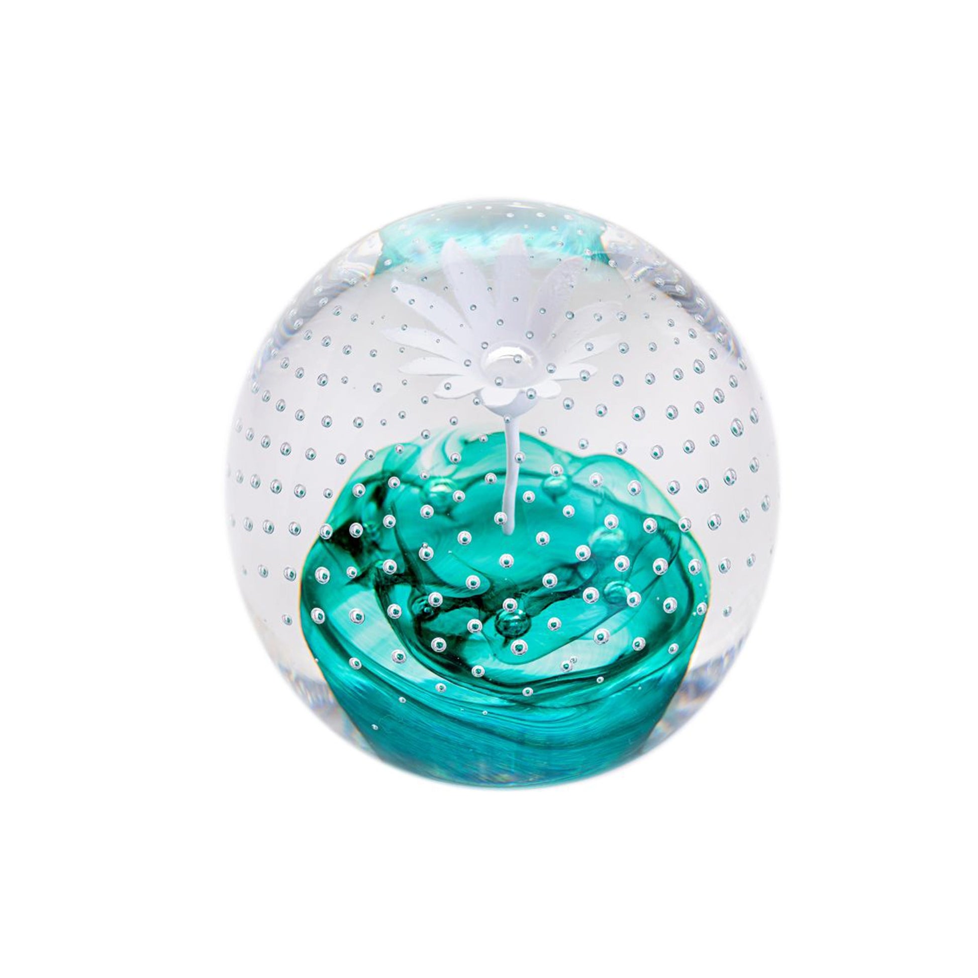 A round glass paperweight with a white flower in the centre on a swirl of emerald green, with bubble details like rain around it