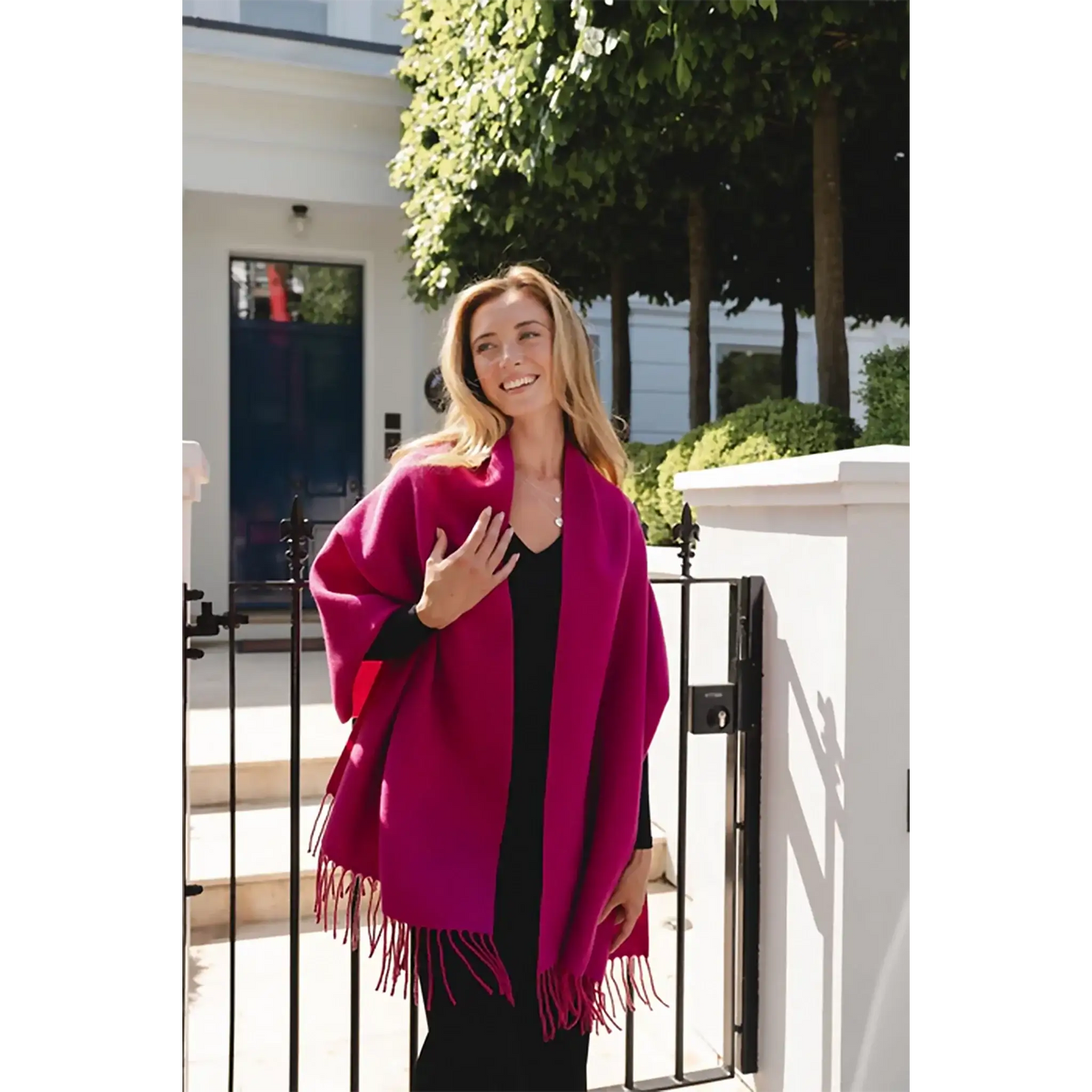 Model wearing two toned bright pink block scarf with tassel trim