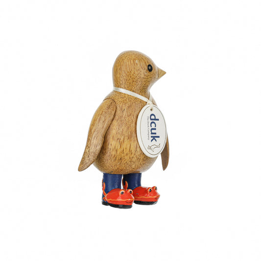 A wooden penguin wearing wellies with red crab design