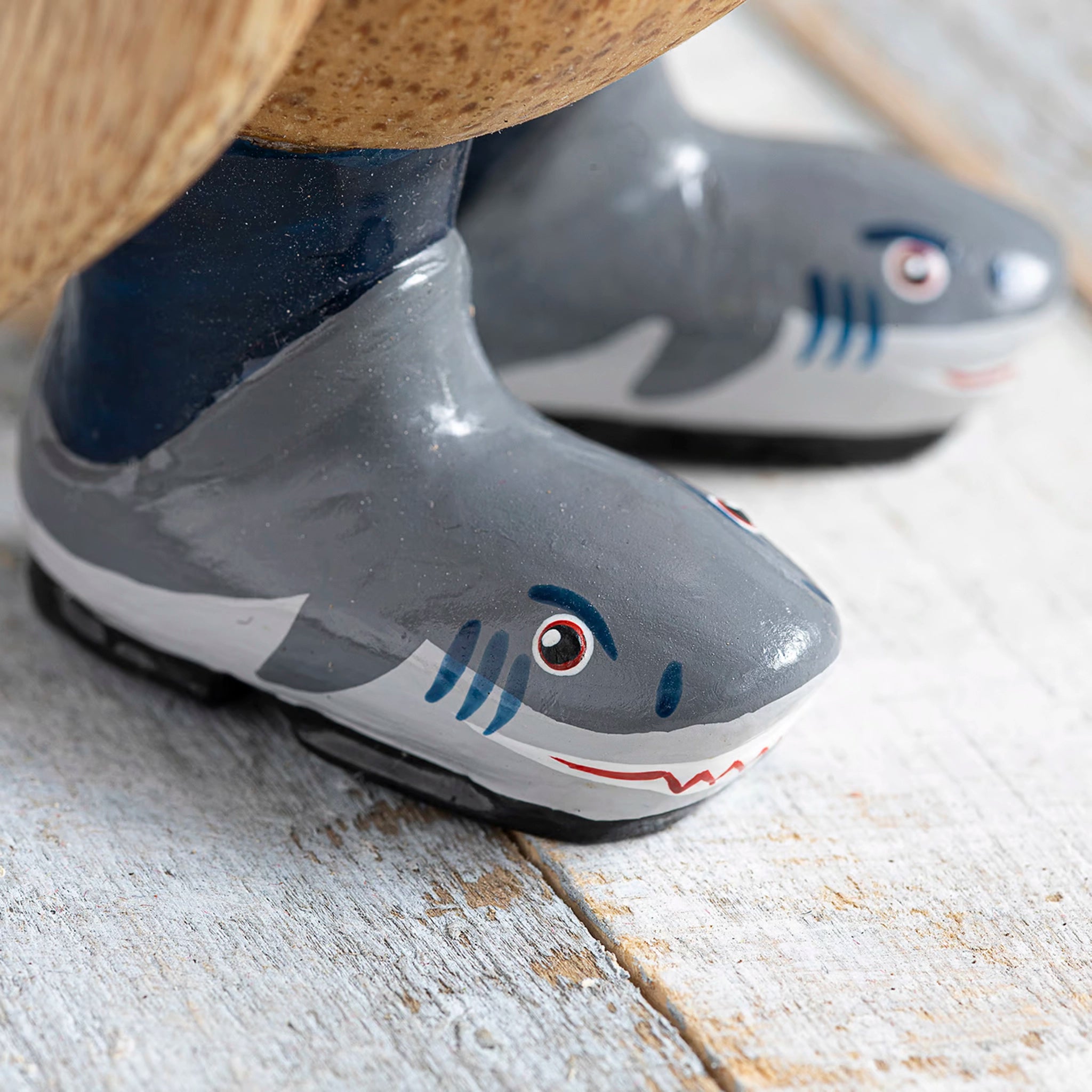 Wooden painted wellies with grey shark design on wooden penguin