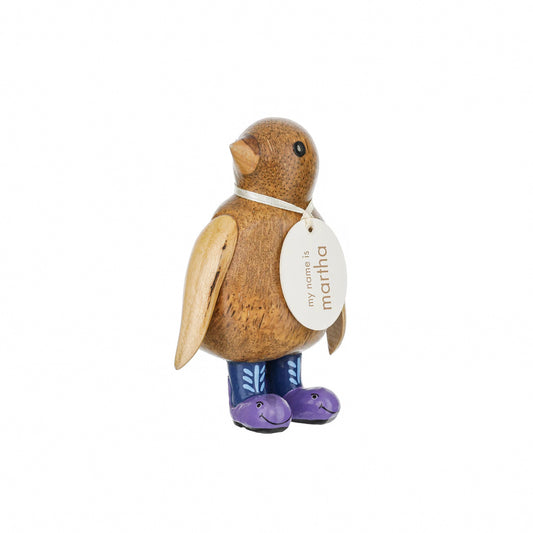 A wooden penguin wearing wellies with purple whale design