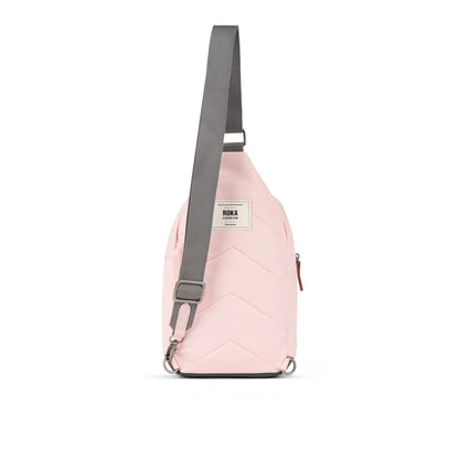 Back of pale pink crossbody sling bag with grey nylon strap