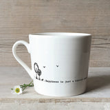 A white ceramic mug with a dog illustration and a quote