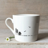 A white ceramic mug with a cabin illustration and a quote