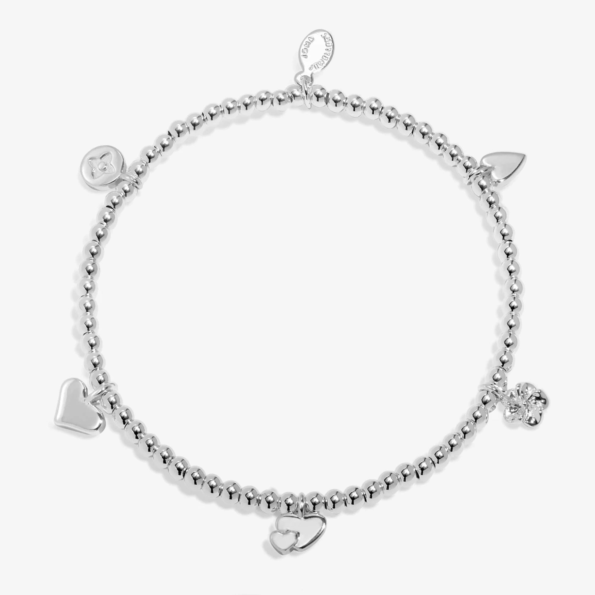 A beaded stretch silver bracelet with five charms, three hearts and two flowers