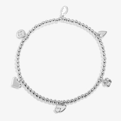 A beaded stretch silver bracelet with five charms, three hearts and two flowers