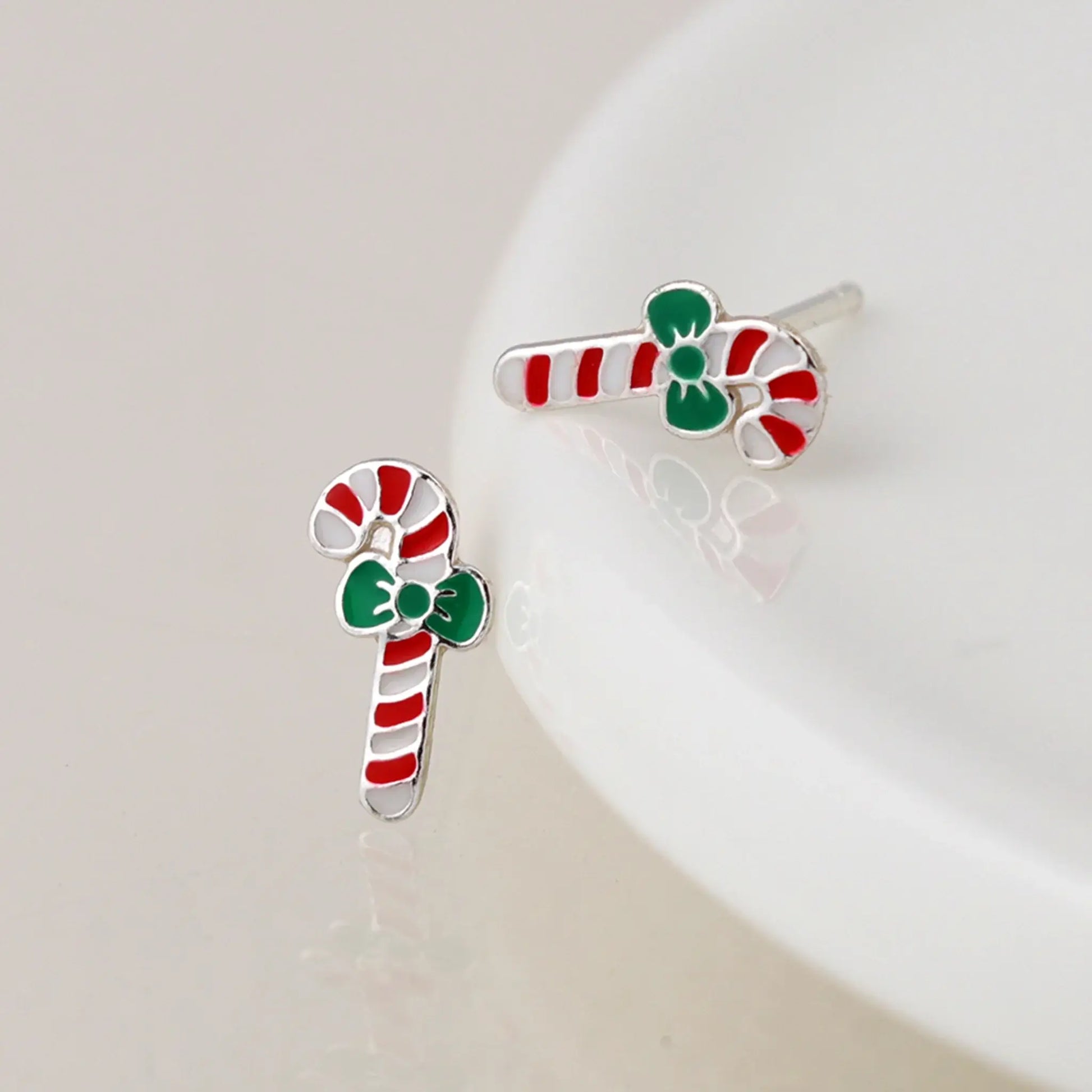 Pair of silver stud earrings shaped like candy canes with enamelled details