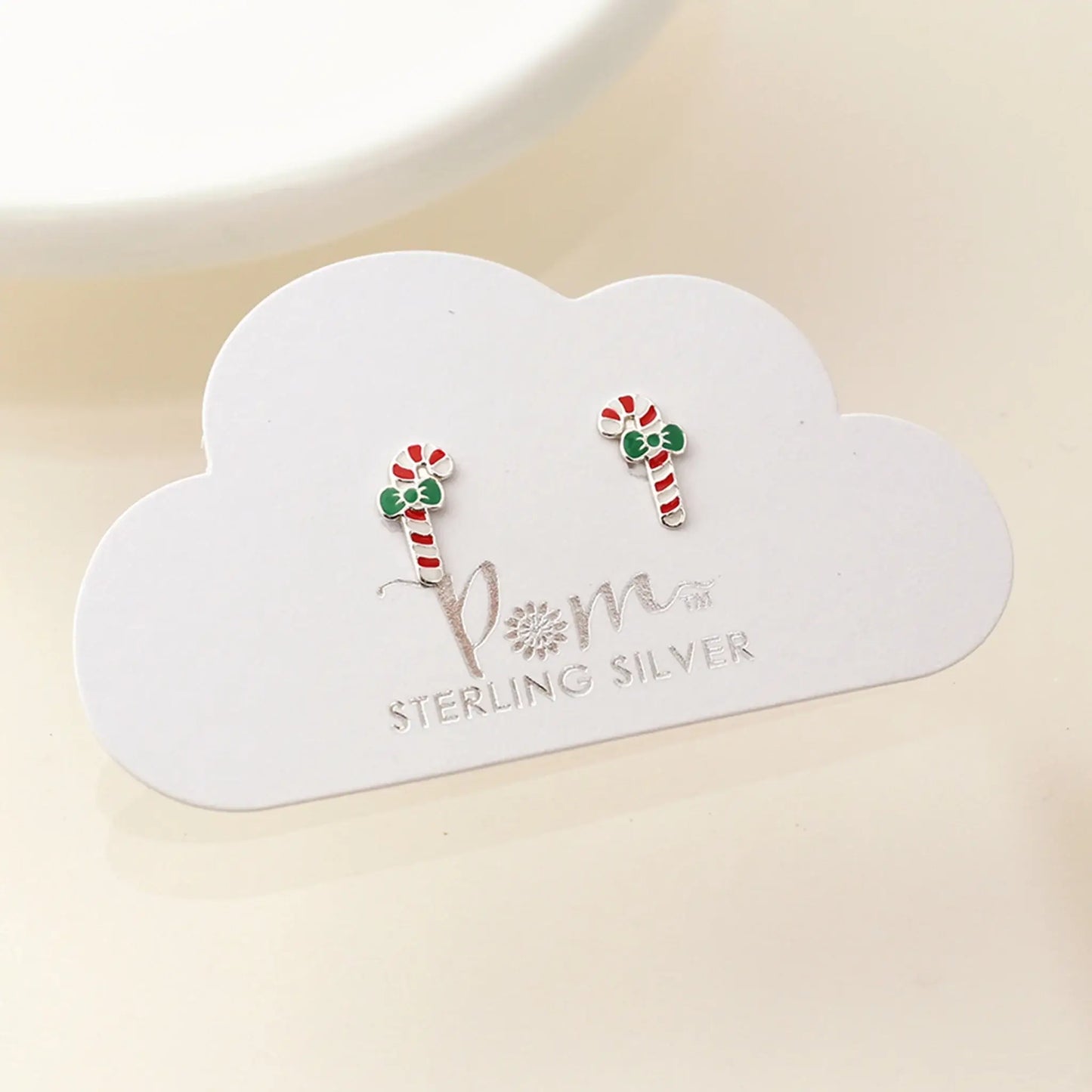 Pair of silver stud earrings shaped like candy canes with enamelled details on card