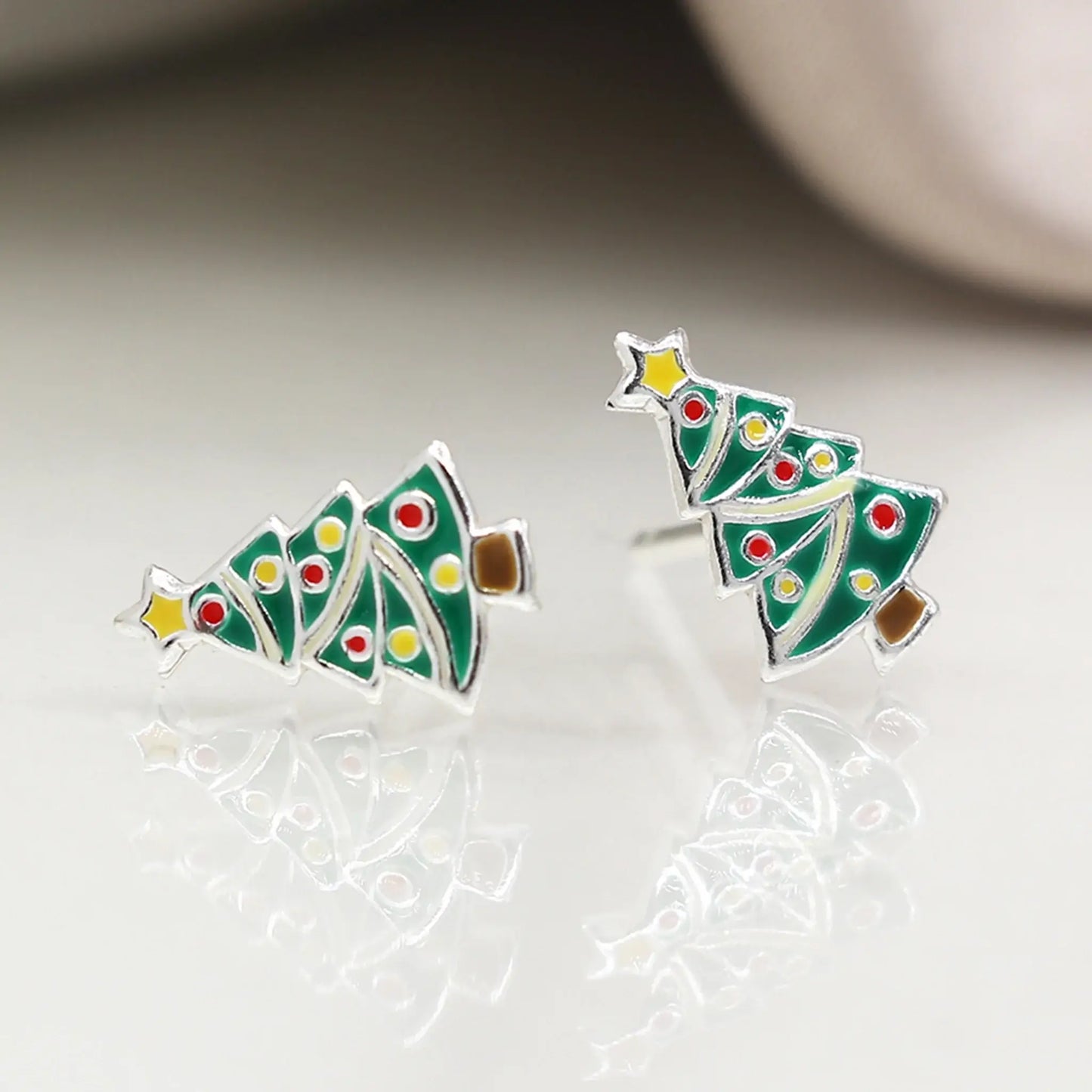 Pair of silver stud earrings shaped like Christmas trees with enamelled details